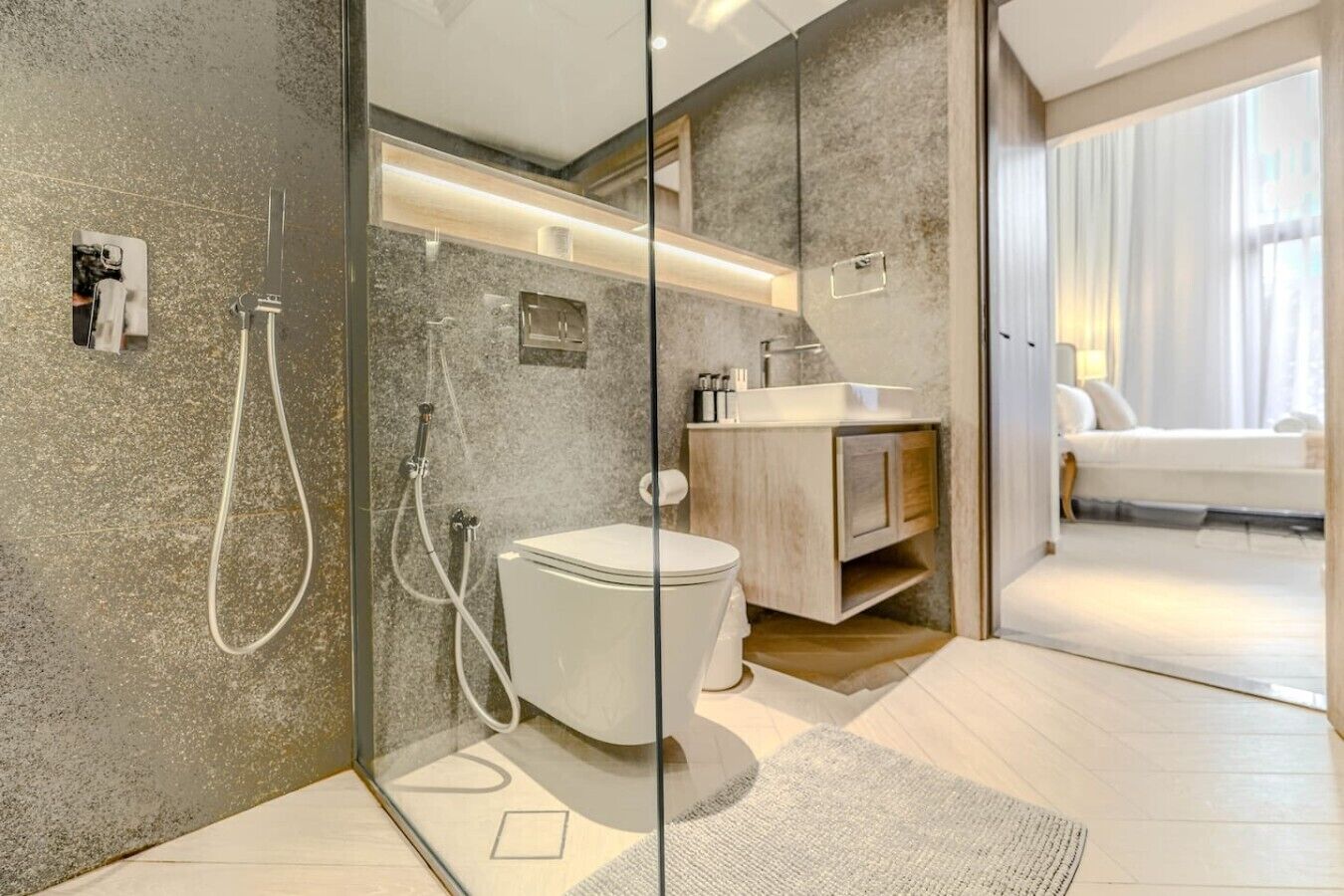 A modern bathroom with a glass shower enclosure, a toilet, and a vanity with a mirror.