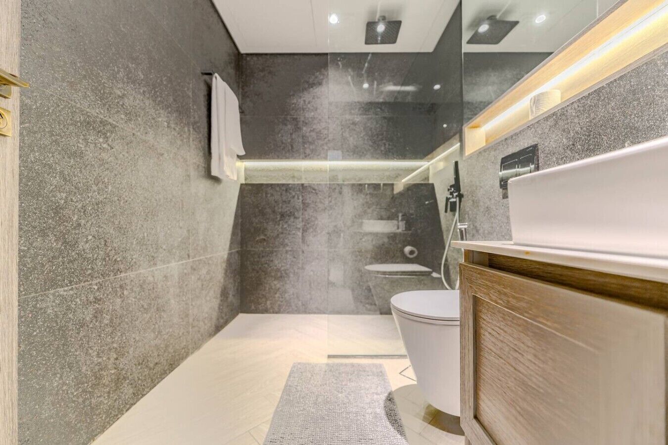 A modern bathroom with a shower, toilet, and vanity.