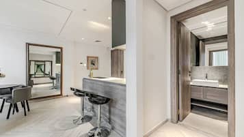 A modern interior with a dining area, a kitchen with a large island, and a bathroom with a wooden vanity.
