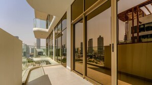 Un bâtiment moderne doté de grandes fenêtres en verre, d’un balcon et offrant une vue sur le paysage urbain.