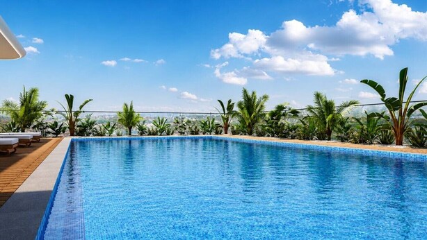 Une piscine d’un bleu éclatant, dotée de chaises longues et agrémentée de plantes tropicales.