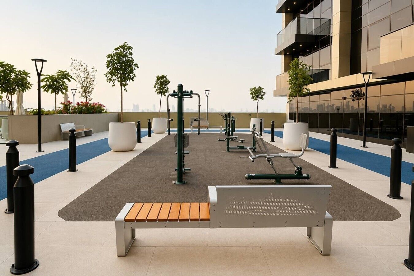Ein Outdoor-Fitnessbereich mit Trainingsgeräten, einer Holzbank und Kübelpflanzen.