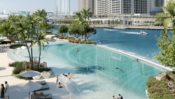 A resort pool with a water slide, lounge chairs, and palm trees. - HAVN - 1 Bed in Cedar 3, Creek Harbour (Dubai)