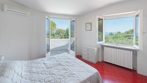 A bedroom with a bed, a radiator, a window, and a door leading to an outdoor area. - Villa Paradiso San Felice del Benaco (Paradiso)