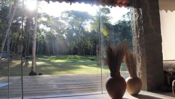 A room with a large sliding glass door leading to a grassy outdoor area.