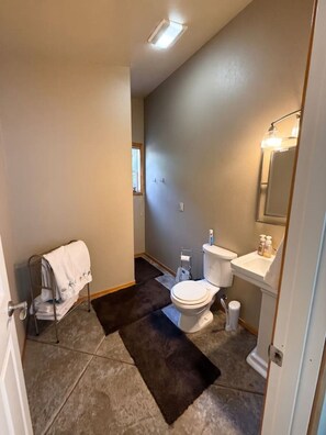 Une salle de bain équipée de toilettes, d’un lavabo et d’un porte-serviettes.
