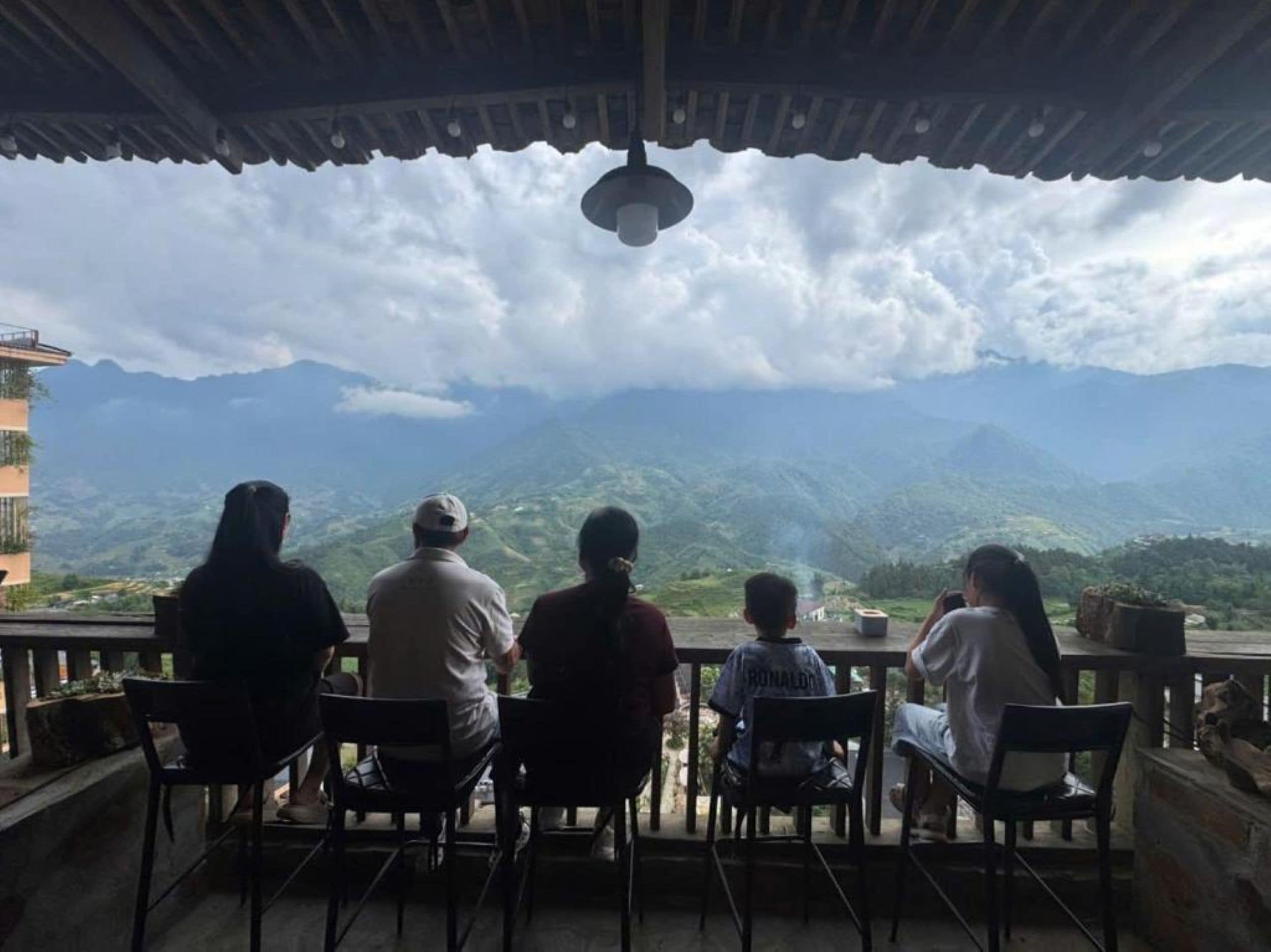 A group of people seated at a table with a view of mountains.