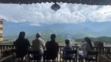 A group of people seated at a table with a view of mountains.