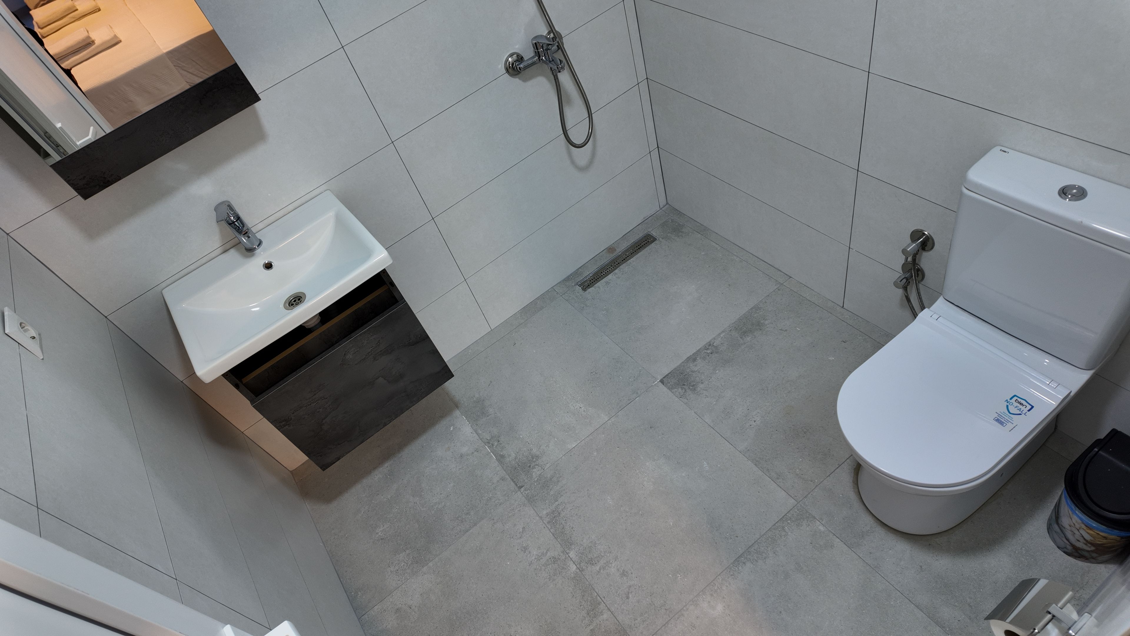 Un baño con un lavamanos blanco, un inodoro y una ducha.