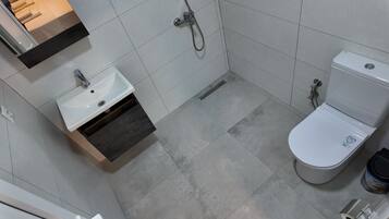 Un baño con un lavamanos blanco, un inodoro y una ducha.