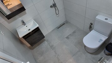 Un baño con un lavamanos blanco, un inodoro y una ducha.