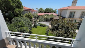A residential area with houses, a well-maintained lawn, and a balcony with a railing.