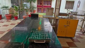 Refrigerador em uma área comum, mesas de jantar