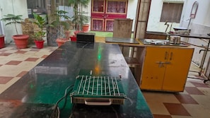 Refrigerador em uma área comum, mesas de jantar