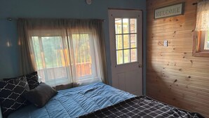 Un dormitorio con una cama, una puerta y un letrero que dice 'WELCOME' en la pared.