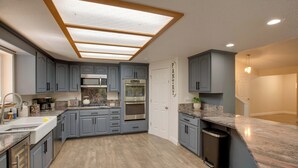 A modern kitchen with grey cabinets, a central island, and a skylight. - Total Seclusion: Pollock Pines Home on 5 Acres (Pollock Pines)