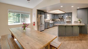 A kitchen with a wooden table, grey cabinets, and a ceiling fan. - Total Seclusion: Pollock Pines Home on 5 Acres (Pollock Pines)