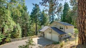 A two-story house with a garage, surrounded by a forested area. - Total Seclusion: Pollock Pines Home on 5 Acres (Pollock Pines)