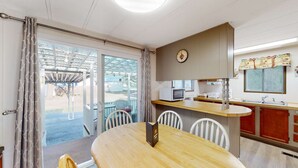 Una cucina compatta con zona pranzo, un forno a microonde e un lavandino.