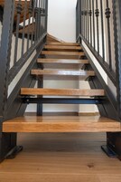 A wooden staircase with metal railings.