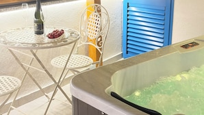 A hot tub, a table with a bottle and glasses, and a chair. - Blažov Dvor (Zaton)