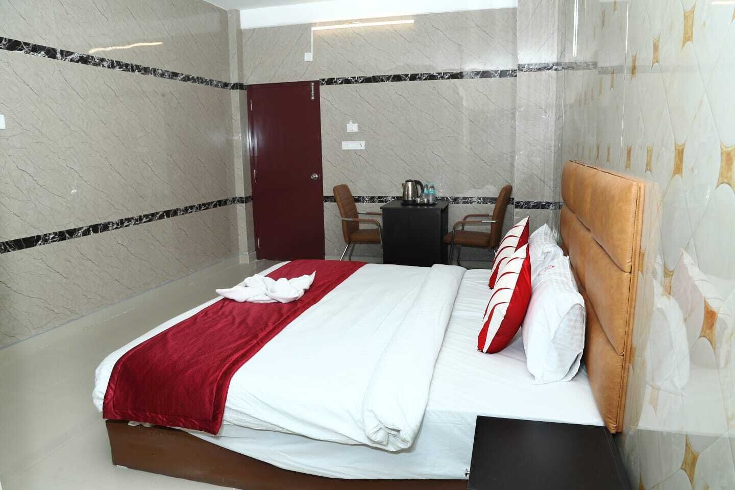Ett hotellrum med en säng, ett skrivbord och en stol.