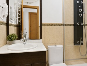 A bathroom with a white sink, a mirror, a toilet, and a shower. - 8-guest Central Madrid Haven (Madrid)