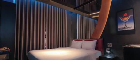 Habitació d'hotel moderna amb un llit gran, una tauleta de nit i un quadre a la paret.