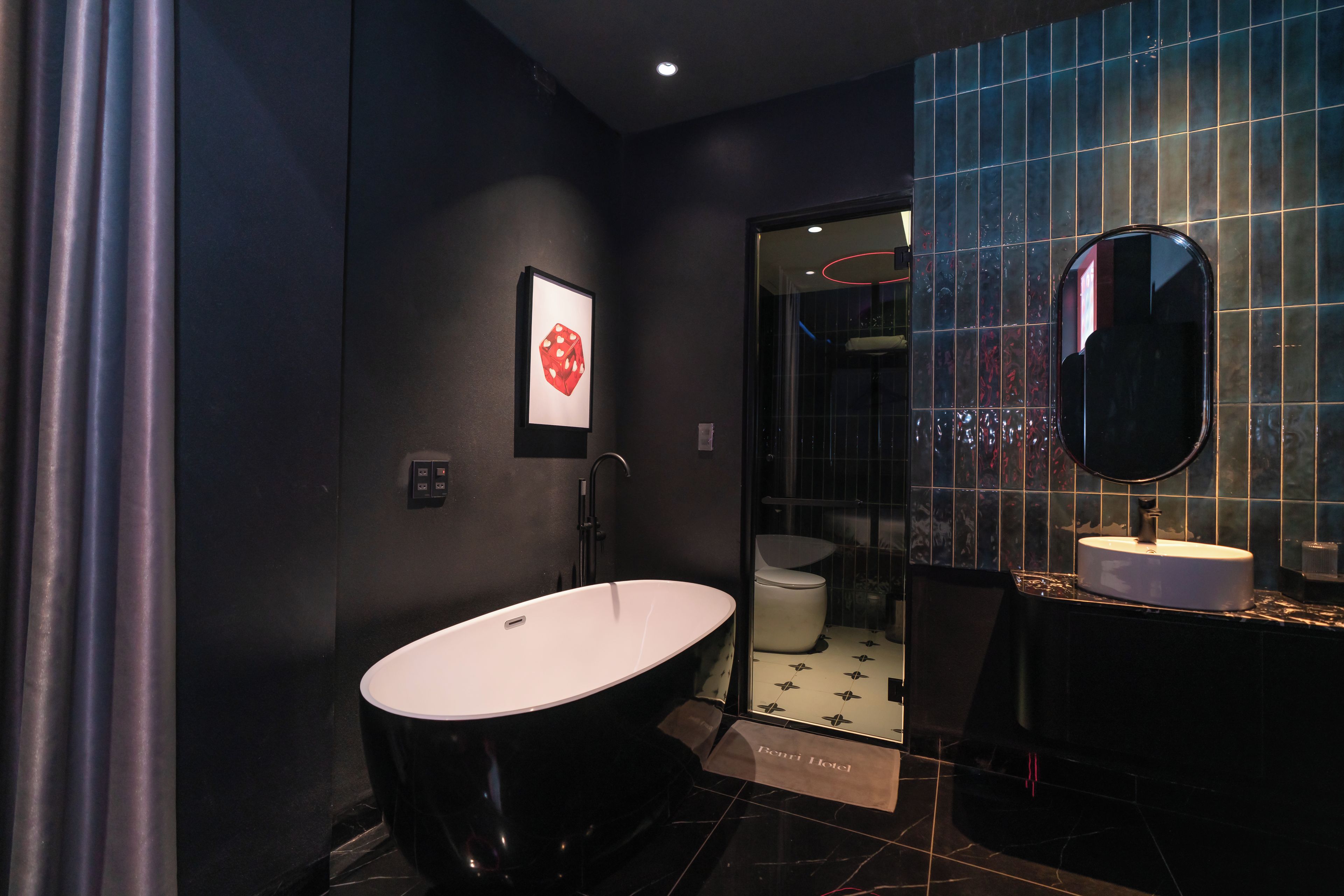 A modern bathroom with a freestanding bathtub, a large mirror, and a framed artwork on the wall.