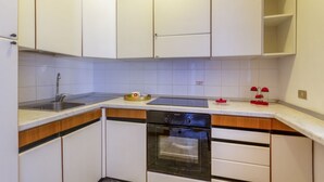 A compact kitchen with white cabinets, a built-in oven, and a stainless steel sink. - A delightful apartment with a balcony that sleeps up to four people, located within the Campoverde Residence in Vernole—set in a Mediterranean pine forest between San Cataldo and the Le Cesine Nature Reserve. The property is just a short distance from  (Campo Verde)