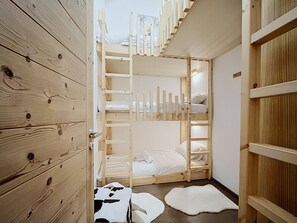 A room with a wooden bunk bed, a wooden wardrobe, and a small rug. - The Fustic Apartment—Accommodates 8 People—Near the Slopes (Les Gets)