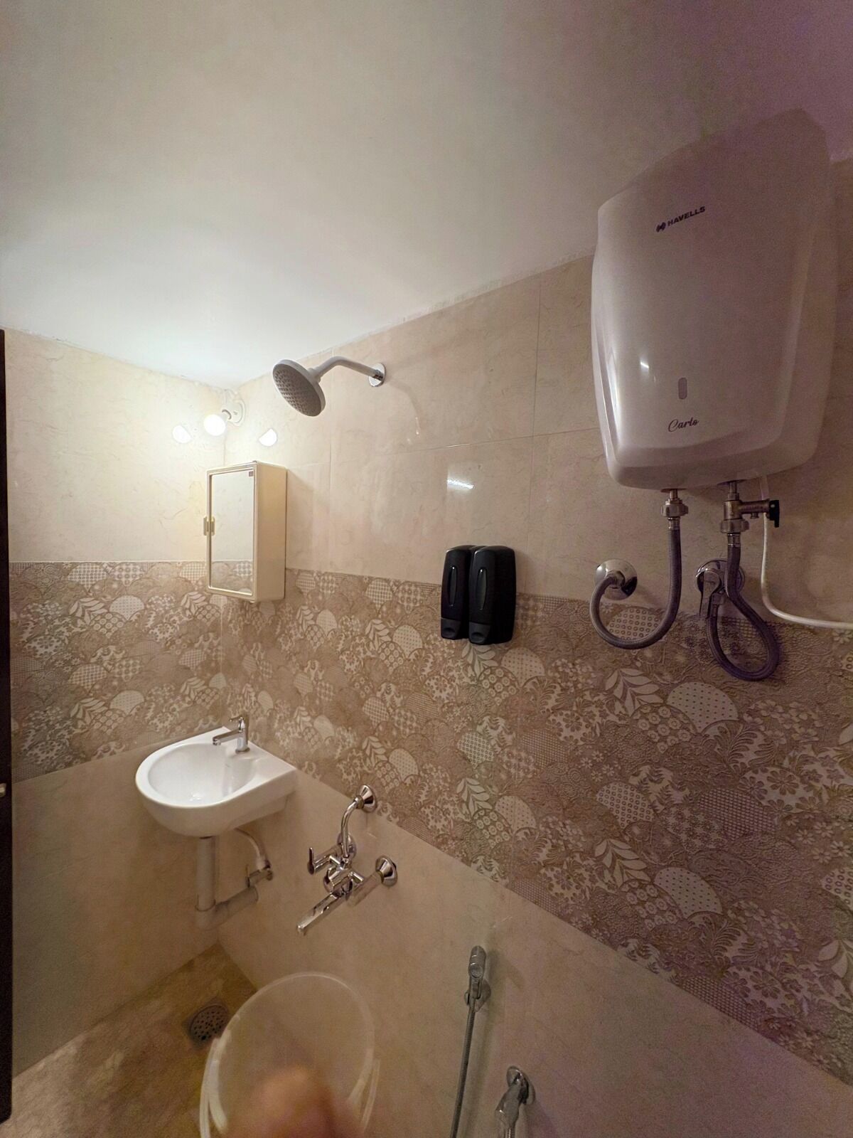 Un baño con lavamanos, cabezal de ducha de mano, inodoro y bidé de pared.