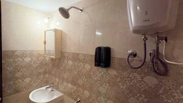 Un baño con lavamanos, cabezal de ducha de mano, inodoro y bidé de pared.