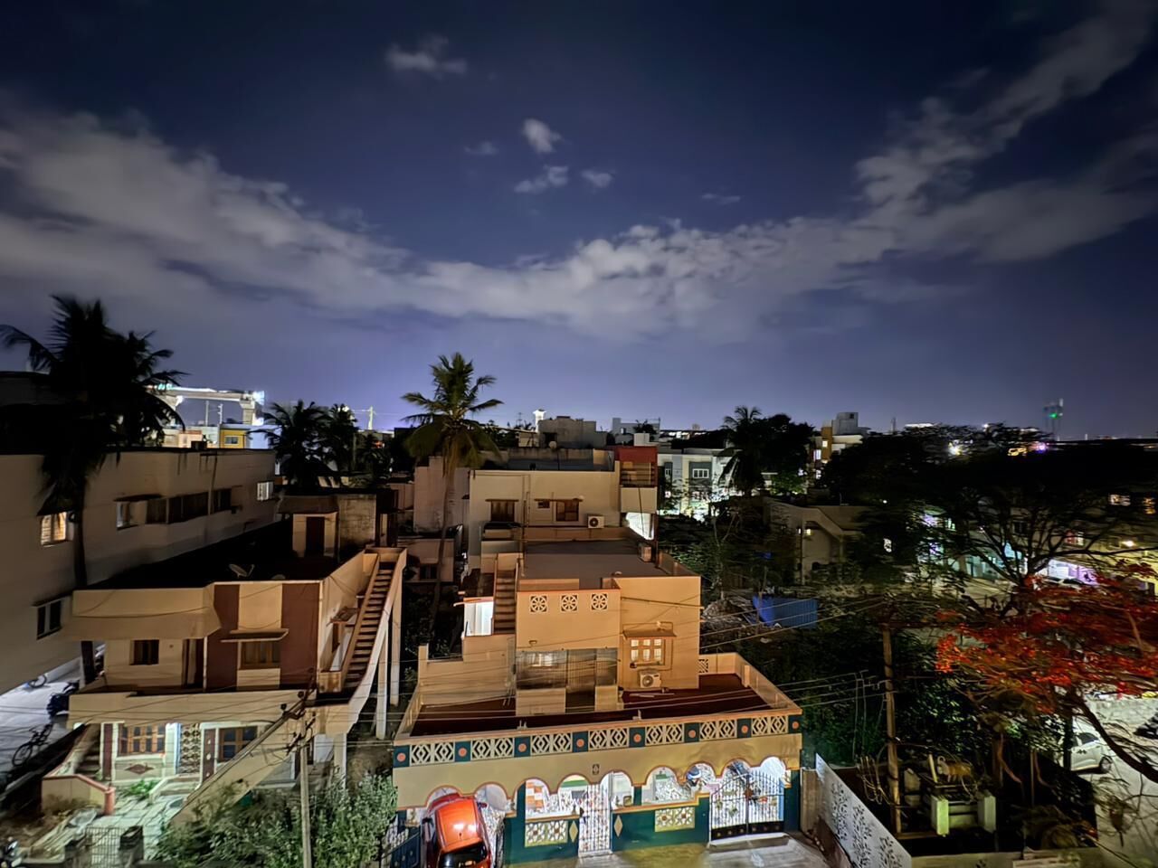 Un edificio residencial de varios pisos con escaleras, balcones y vistas del barrio circundante durante la noche.