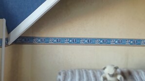 Un lit superposé avec une couvre-lit à motifs et un ciel de lit bleu.