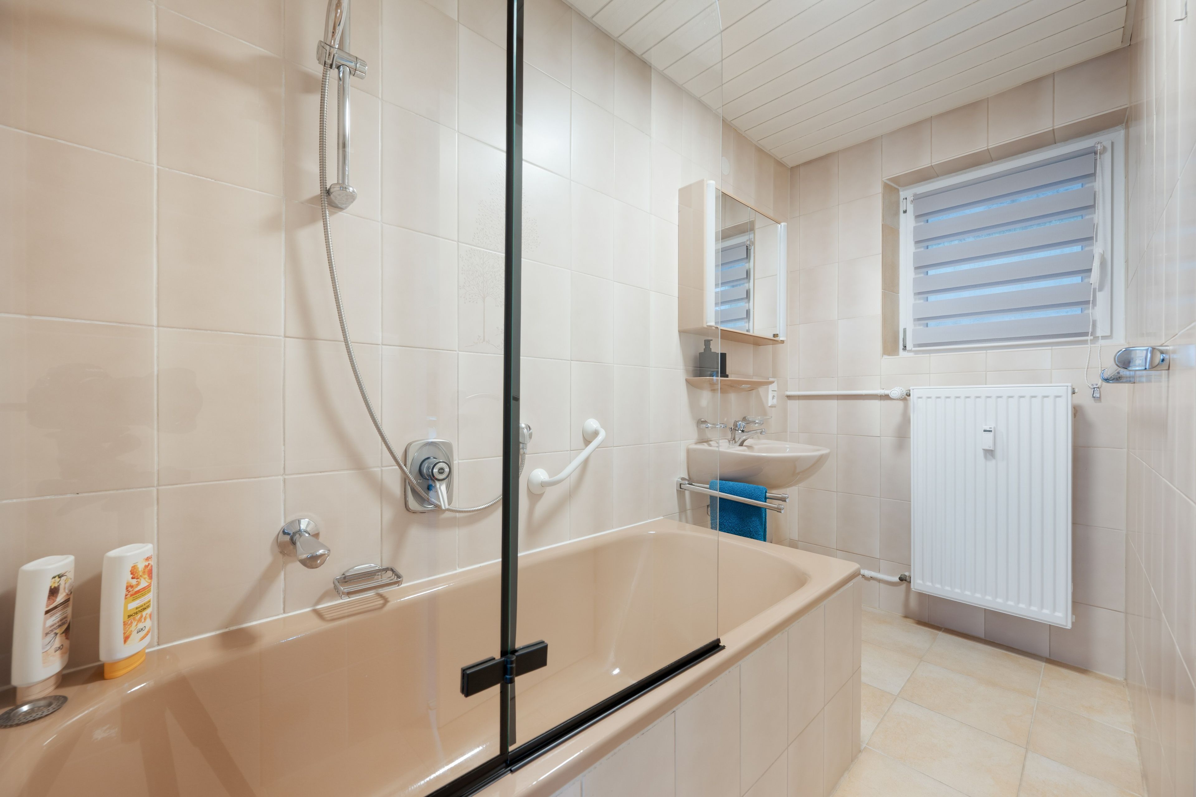 Ein modernes Badezimmer mit einer Badewanne, einer Dusche, einem Waschbecken und einem Spiegel.
