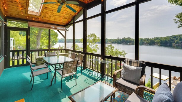 A covered outdoor deck with a table and chairs, overlooking a lake. - 2 Mi to Six Flags: Lakefront 2-Camp Combo (Queensbury)