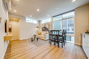 A modern apartment with a dining area, a sofa, and a kitchen. - Rooftop Brews & Mtn Views: Central Seattle Gem (Seattle)