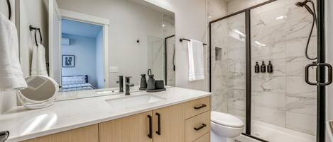 Un bagno moderno con doccia, servizi igienici e lavabo.