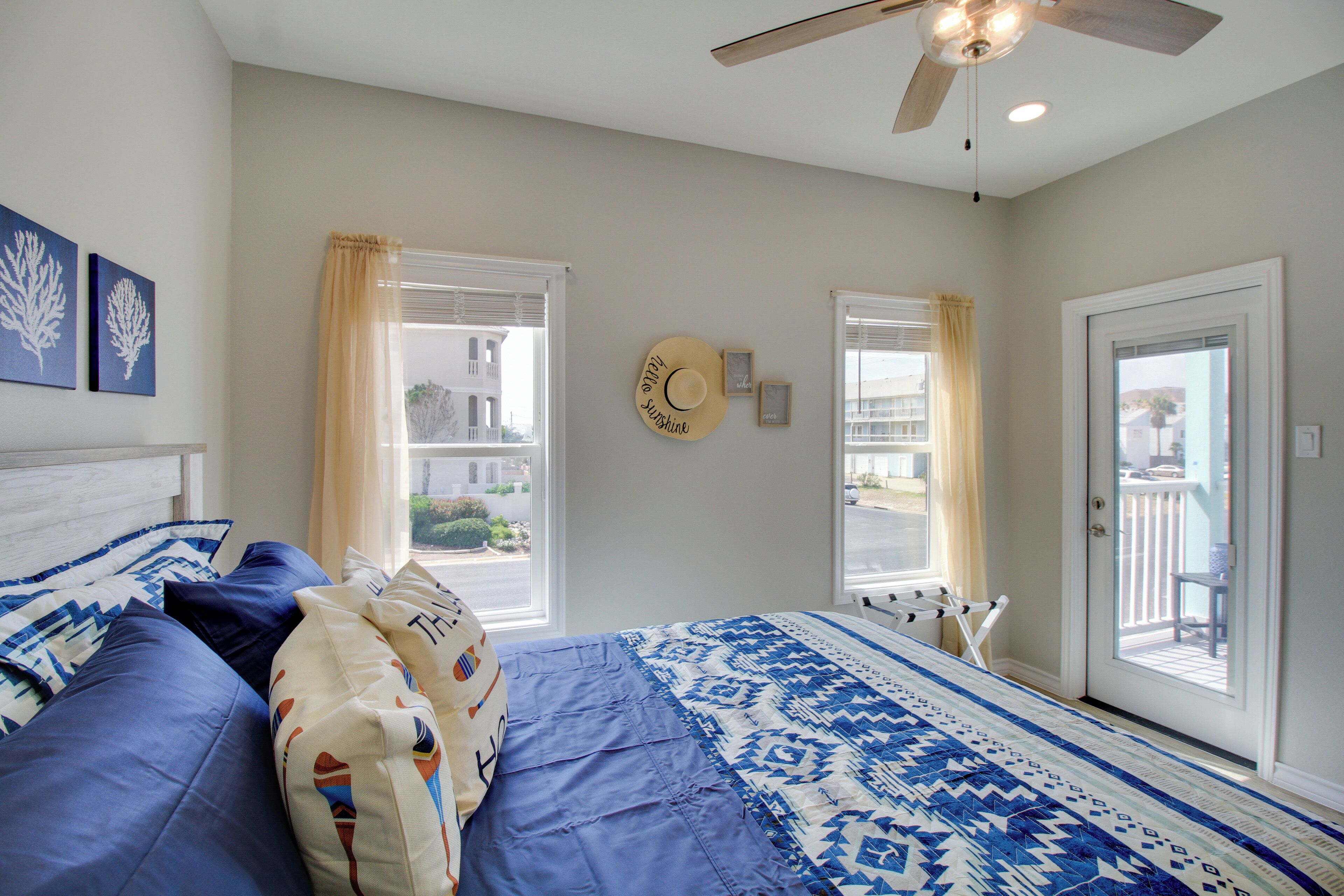 Une chambre avec un lit, un ventilateur de plafond et une vue sur l’extérieur.