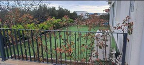 A balcony with a metal railing, a view of a green lawn, and a building in the background. - Villa PIA Luxurious Seaside Villa, Ground Floor - Onsite pool, 3 bedrooms, Private parking (Okrug Gornji)