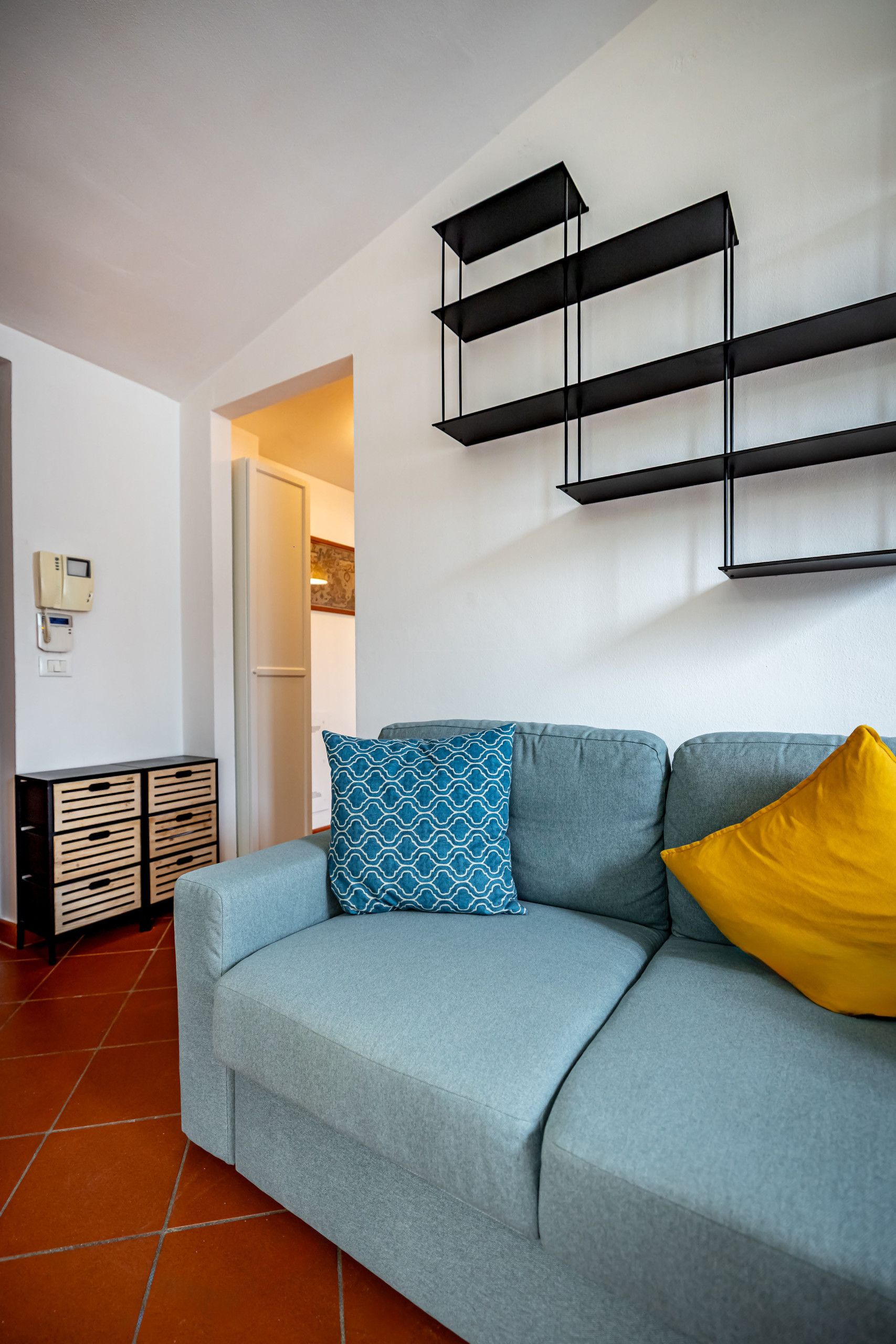 Una sala de estar con sofá, una mesa de centro y una estantería de pared.
