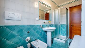 Un bagno con un lavandino bianco, un bidet, un water e una zona doccia.