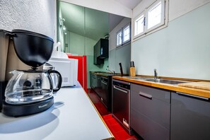 Eine moderne Küche mit Kaffeemaschine, Geschirrspüler und einer Holzarbeitsplatte.