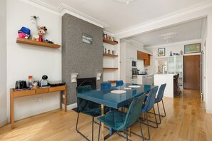 A modern kitchen with white cabinets, a microwave, and a coffee machine. - New! Modern Family 4BR Home | Patio | Harringay (Greater London)