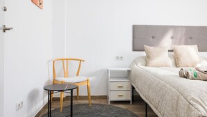 A bedroom with a bed, a chair, a small table, a bedside table, and a wall-mounted artwork. - Monte Taxco 9 Apartment (Torrent)