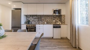 A modern kitchen with white cabinets, a built-in oven, and a dishwasher. - Monte Taxco 9 Apartment (Torrent)