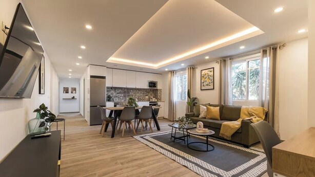 A modern living room with a dining area, kitchen, and a sofa with a view of the outdoors. - Monte Taxco 9 Apartment (Torrent)