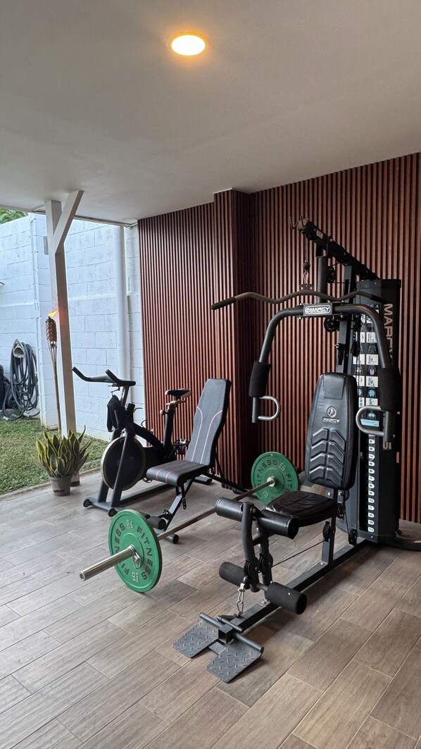 A gym with exercise equipment, a bench, and a wall with vertical lines.