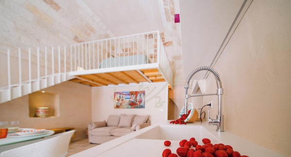 Ein modernes Interieur mit einem Etagenbett, einem Waschbecken mit roten Früchten und einem Bild an der Wand.